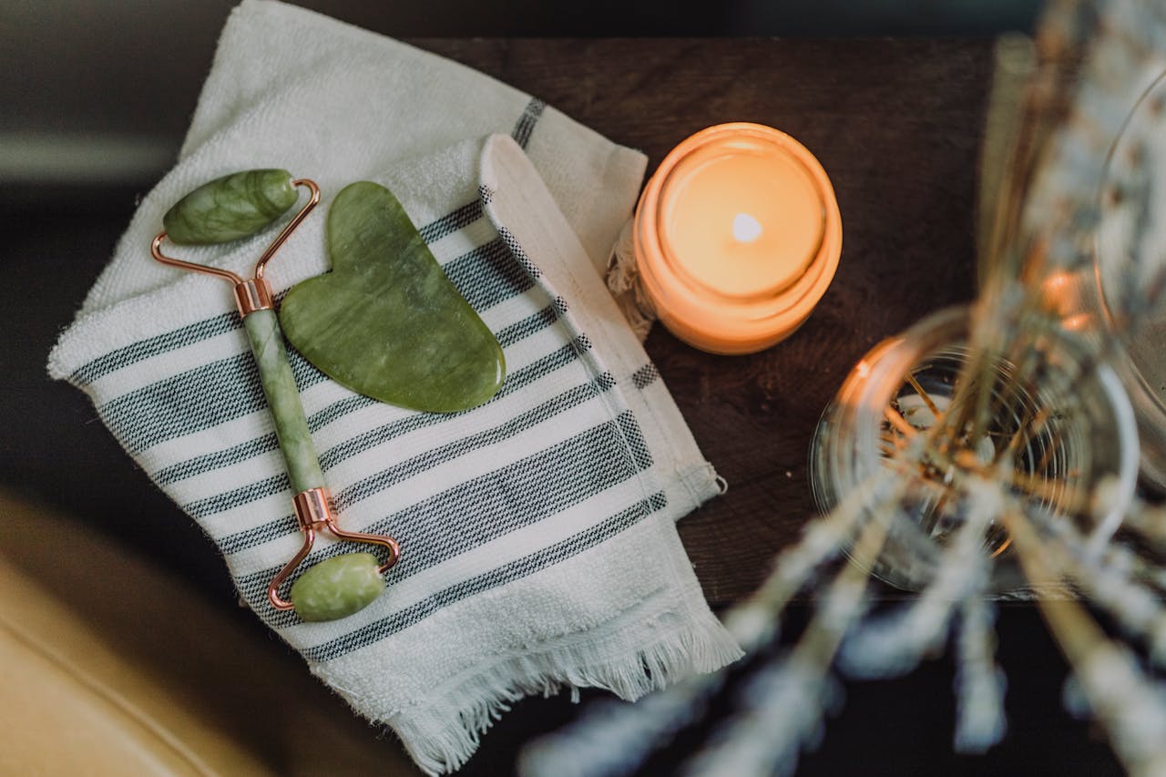 services-02 A serene spa setup featuring a jade roller, gua sha, towel, and candle for ultimate relaxation.